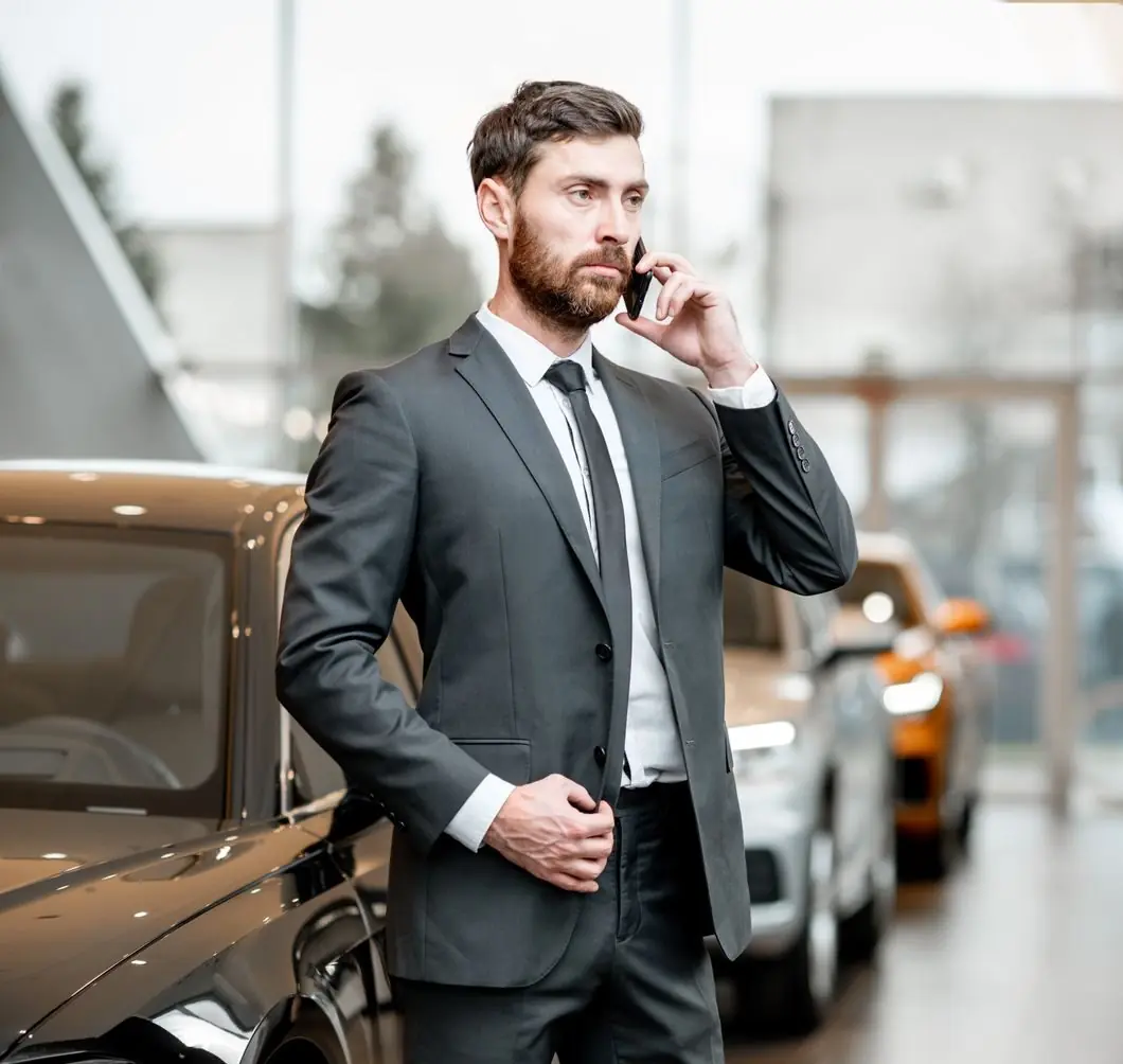 businessman-with-phone-in-the-car-showroom-Z4GX4UW-e1741905609723.jpg